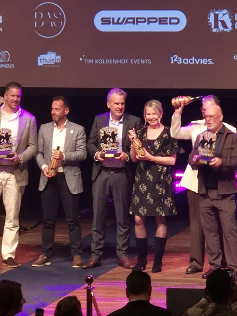 Het team van Scholten Panelen met de awards op het podium